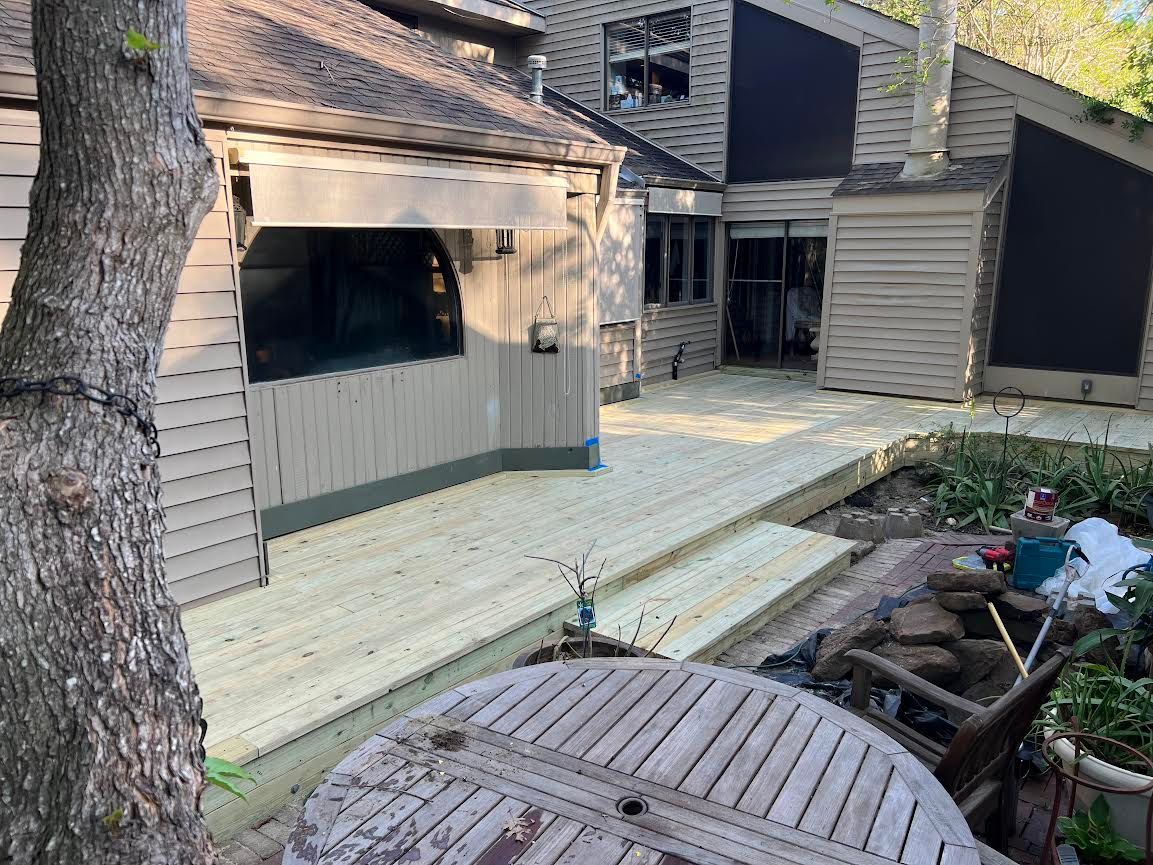 A wooden deck is being built in front of a house.