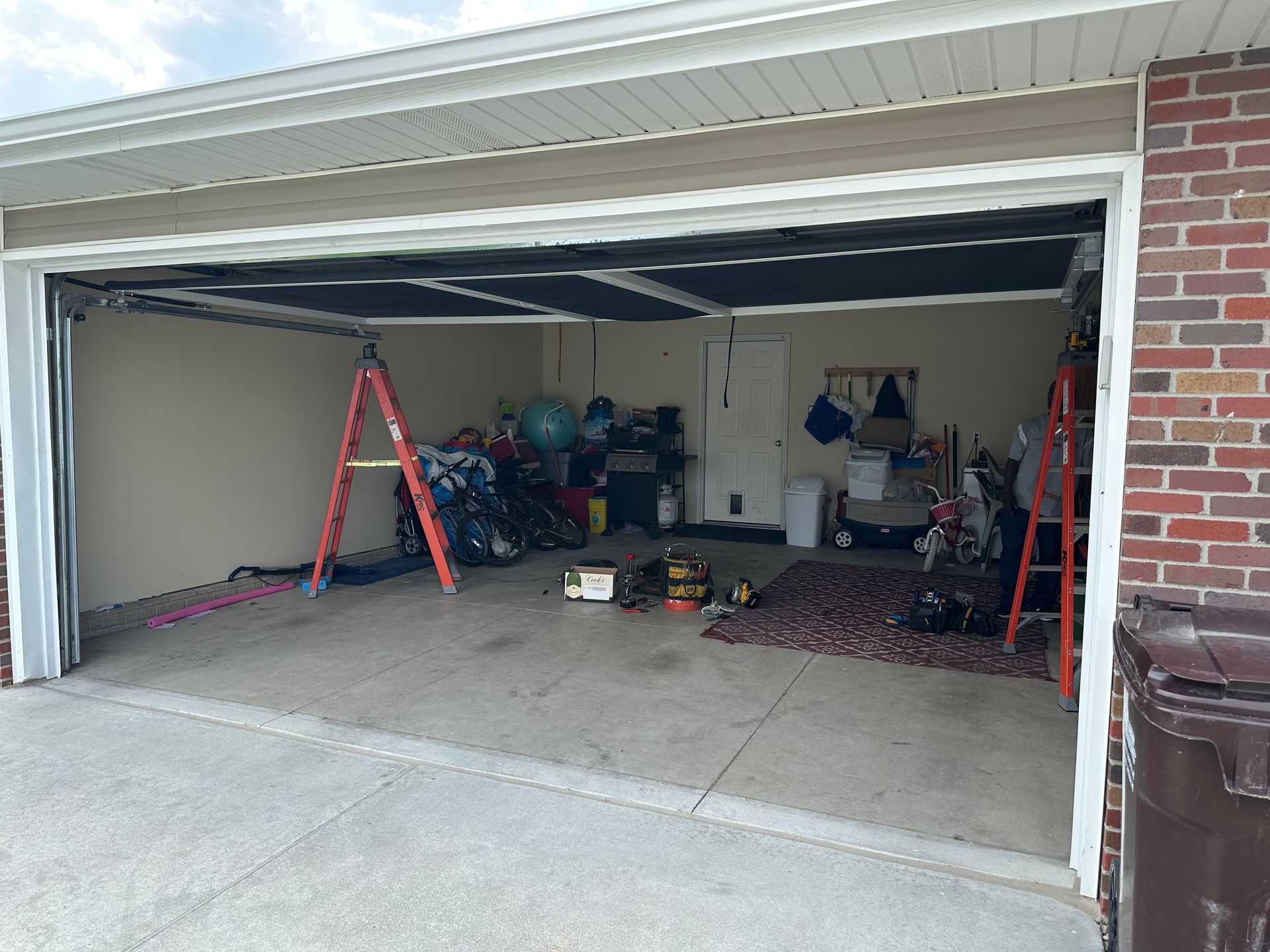 A garage with a ladder in it and a brick wall.