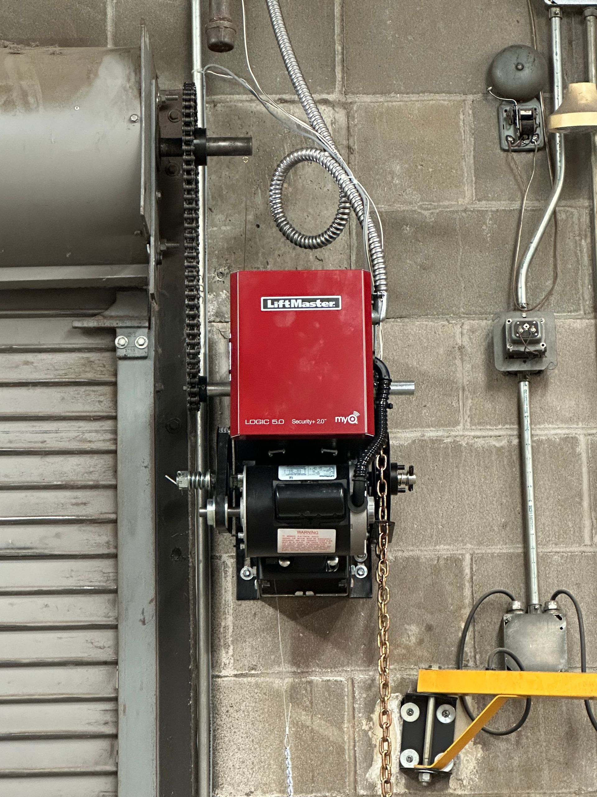 A garage door opener is attached to a brick wall