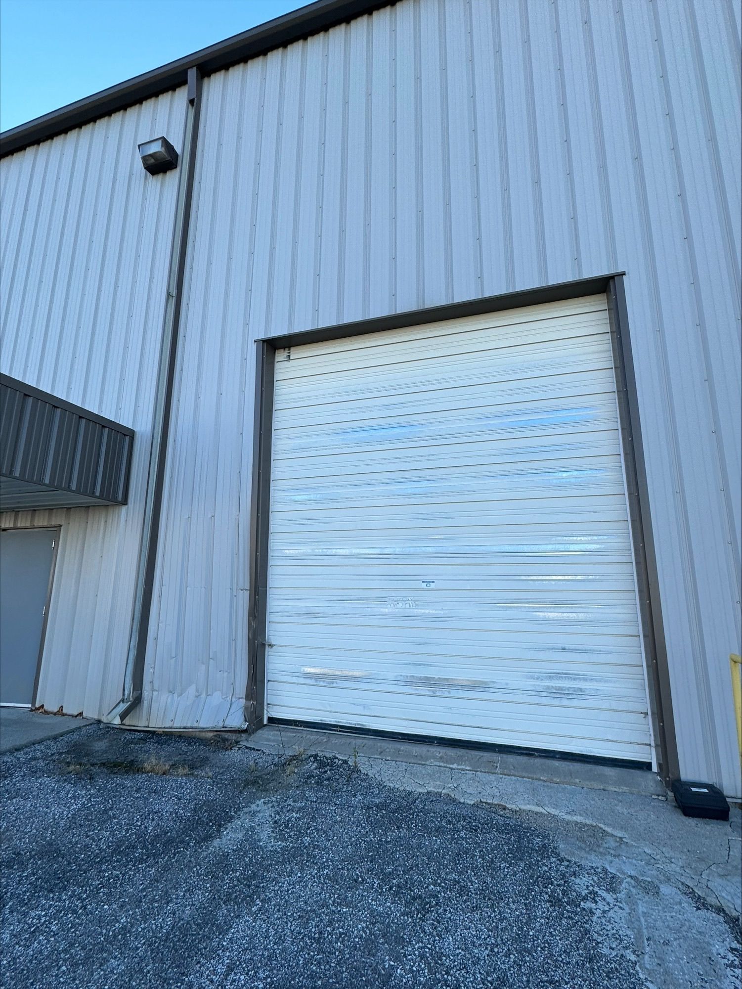 A white garage door is on the side of a building.