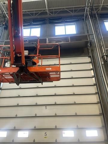 A lift is sitting on top of a large garage door.