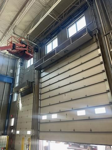 A large garage door is open in a large building.