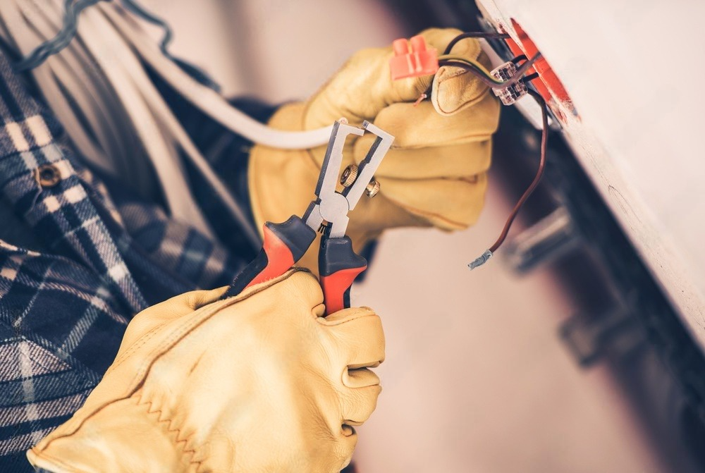 Person installing electrical sockets in a newly constructed apartment.