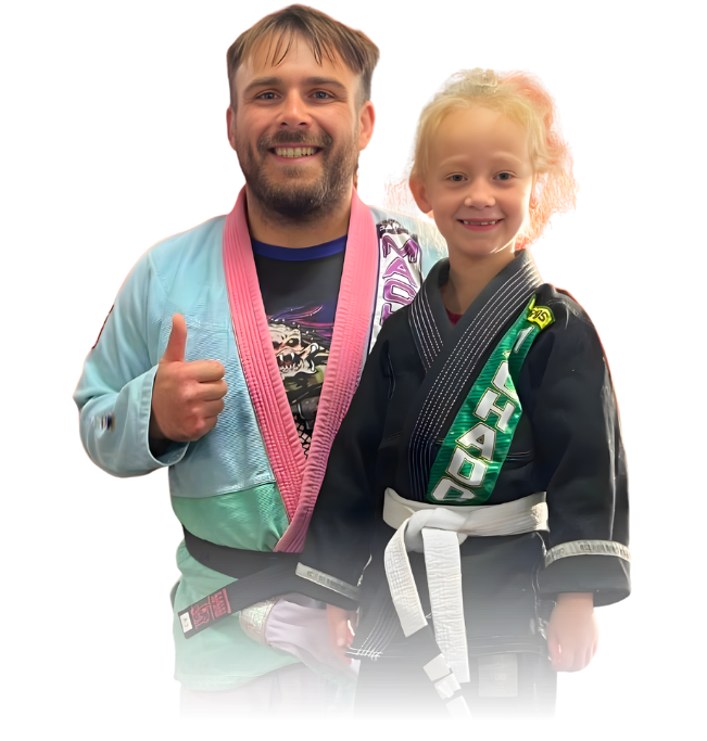 Man pointing, smiling, wearing black hoodie; arm tattoo visible.