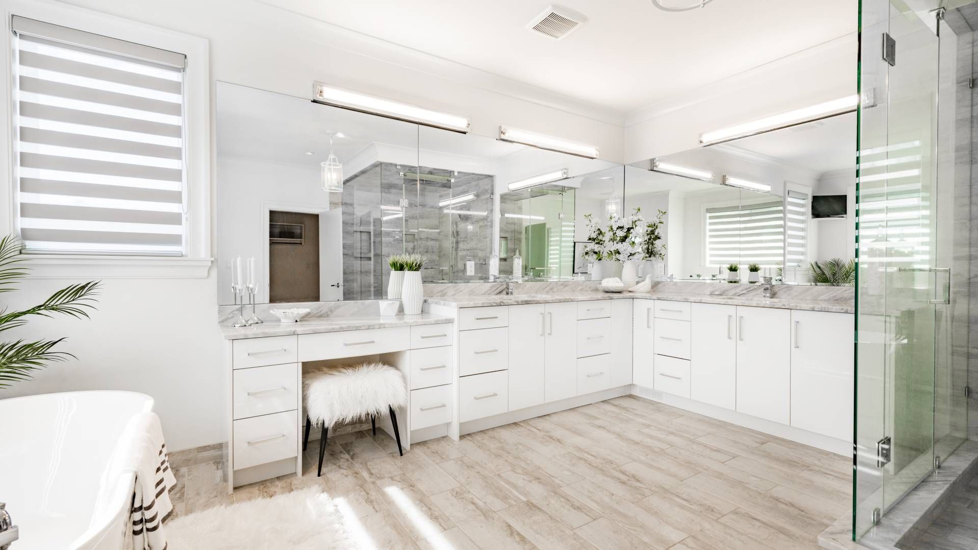 A bathroom with two sinks , a tub , and a walk in shower.