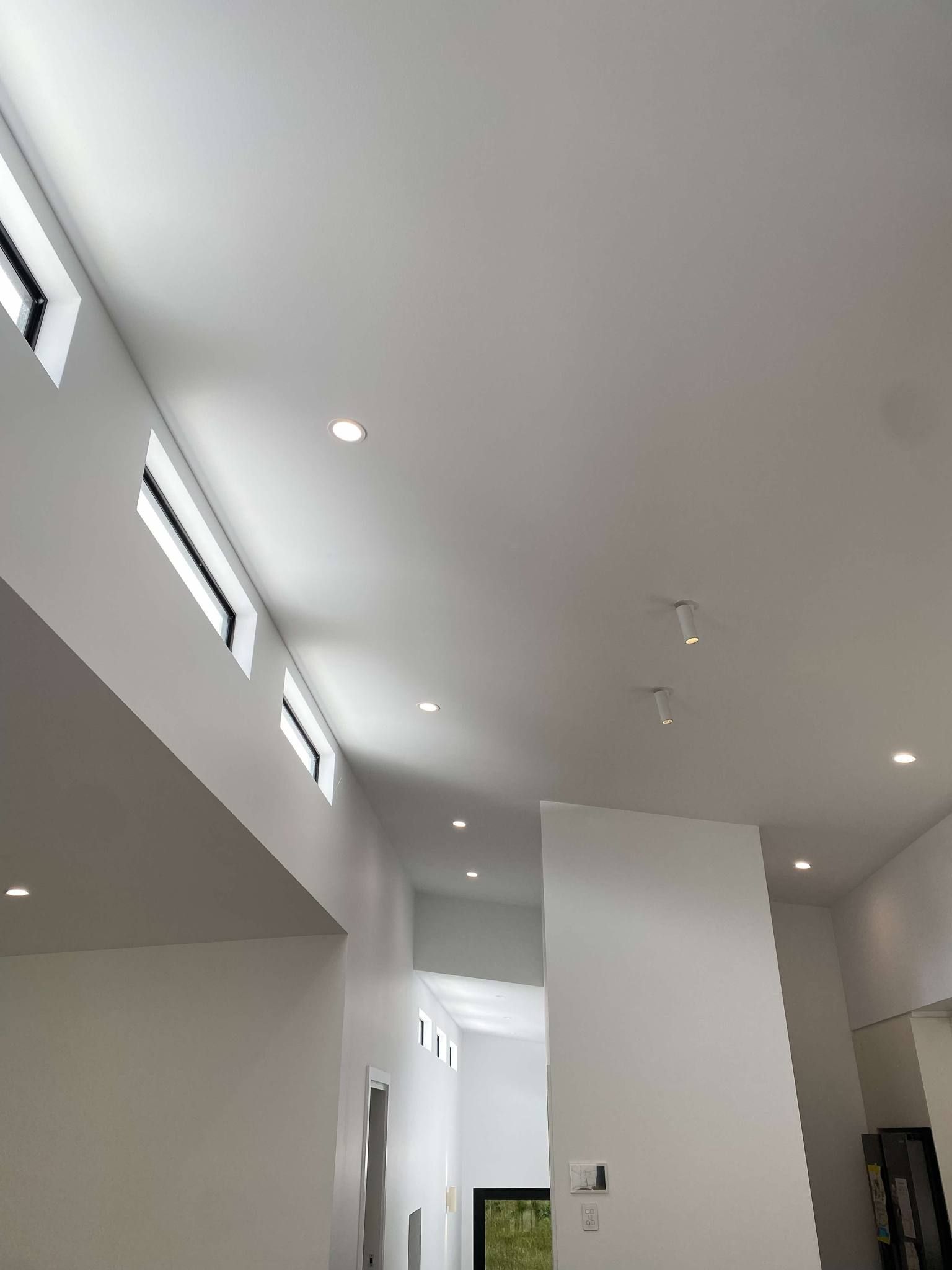 A White Air Conditioner is Hanging on a White Wall — Anderson Electrical & Air in Wingham, NSW