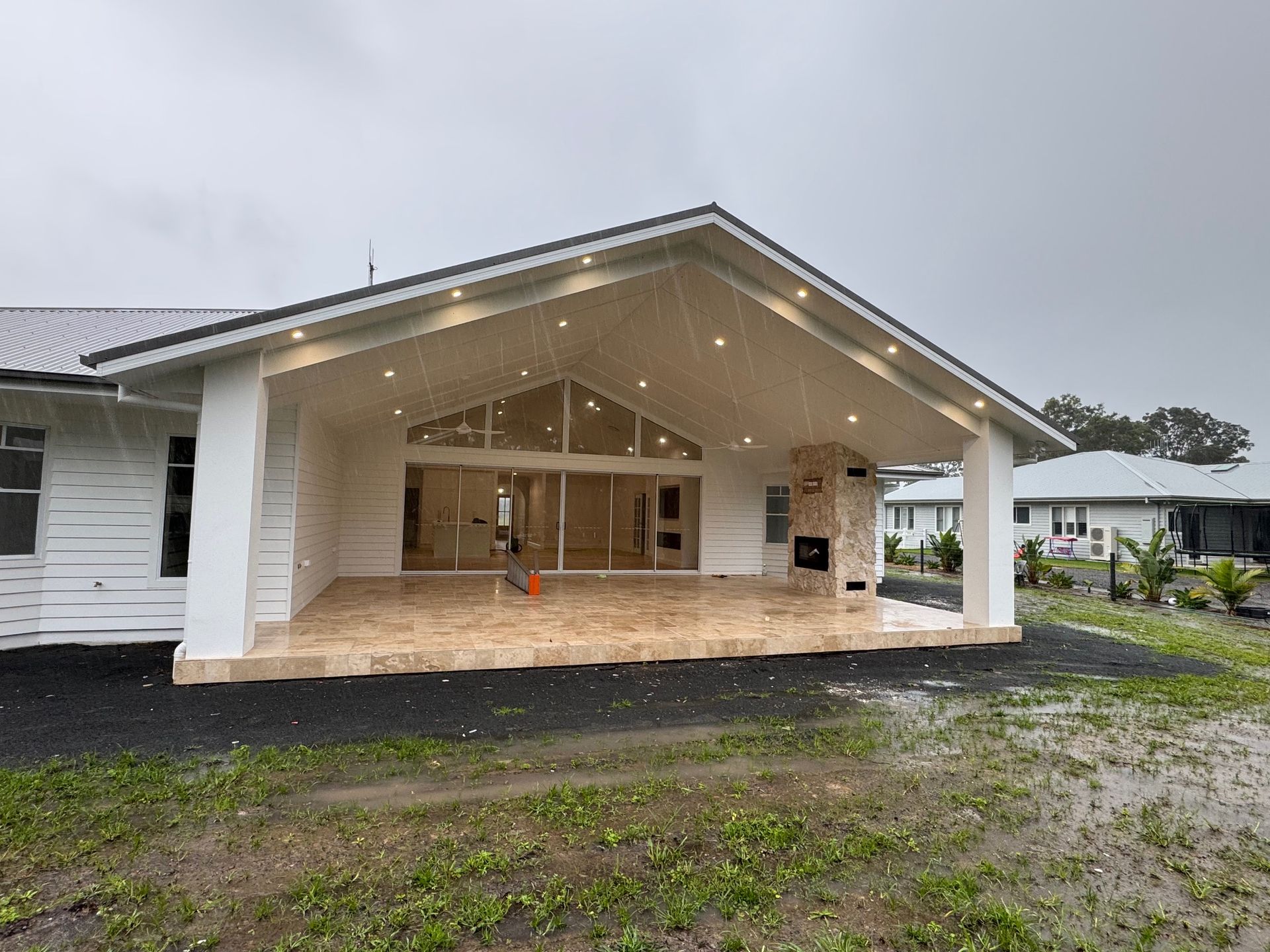 The back of a white house with fairy lights and a large porch — Anderson Electrical & Air in Taree, NSW