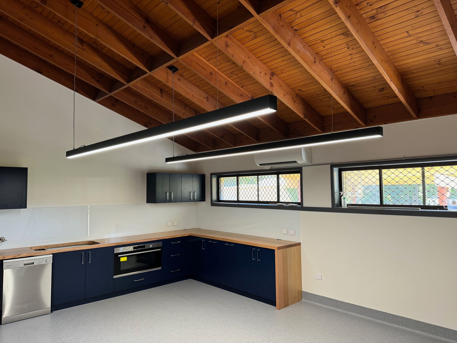 A living room with lights hanging from the ceiling — Anderson Electrical & Air in Taree, NSW