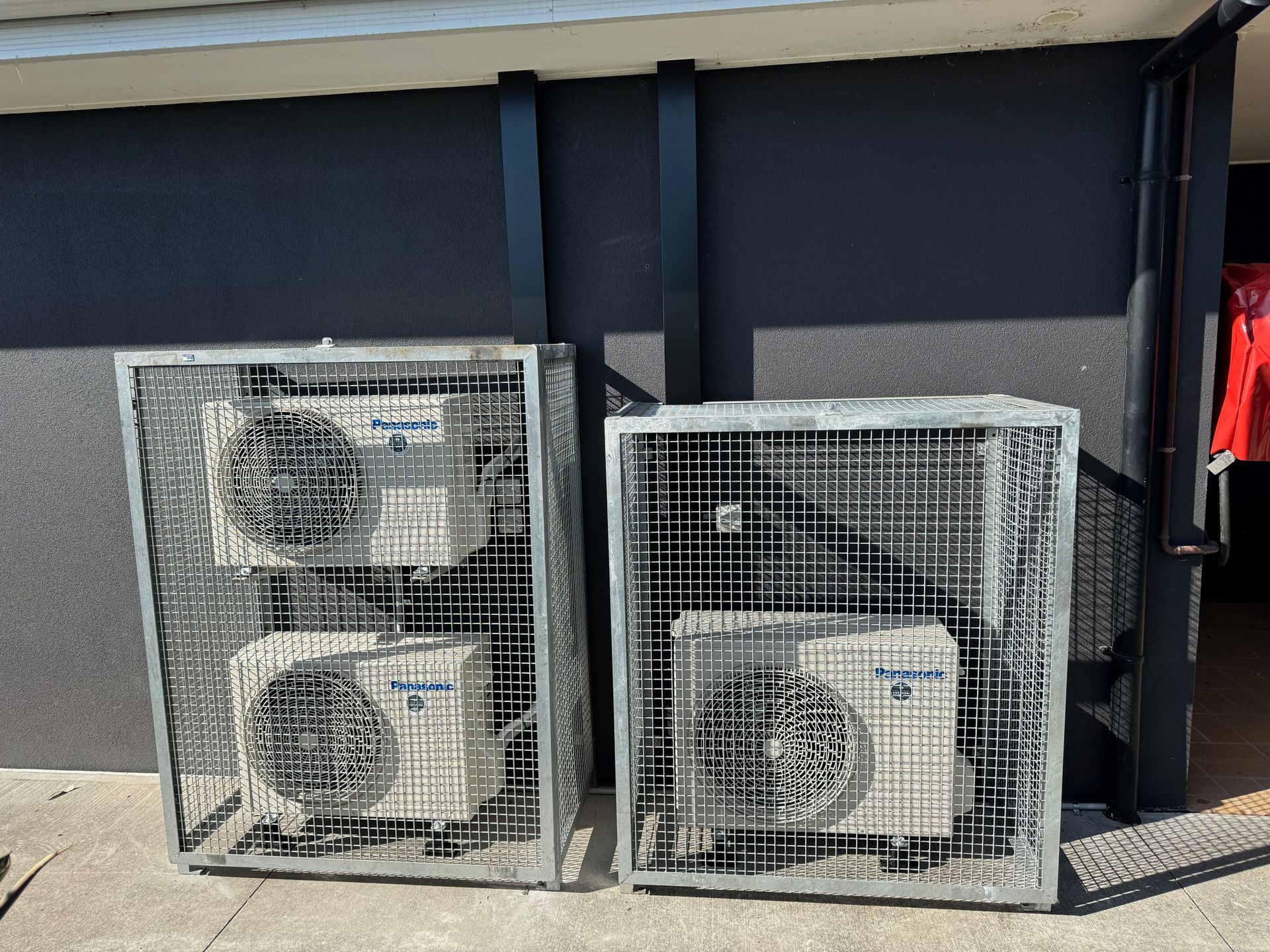 A Man is Working on a Ceiling Mounted Air Conditioner — Anderson Electrical & Air in Tuncurry, NSW