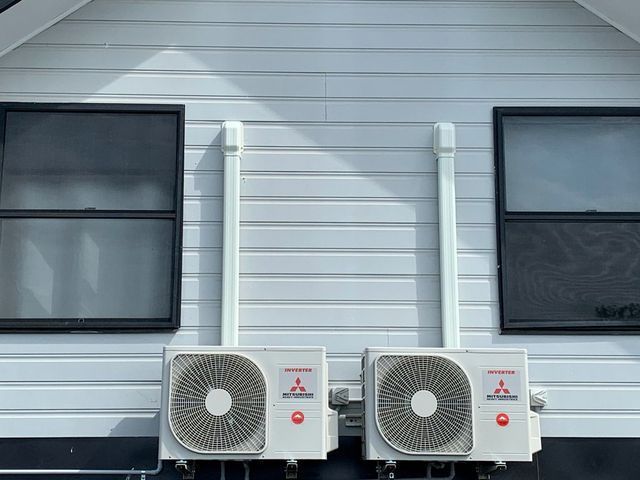 Two air conditioners are mounted on the side of a house — Anderson Electrical & Air in Taree, NSW