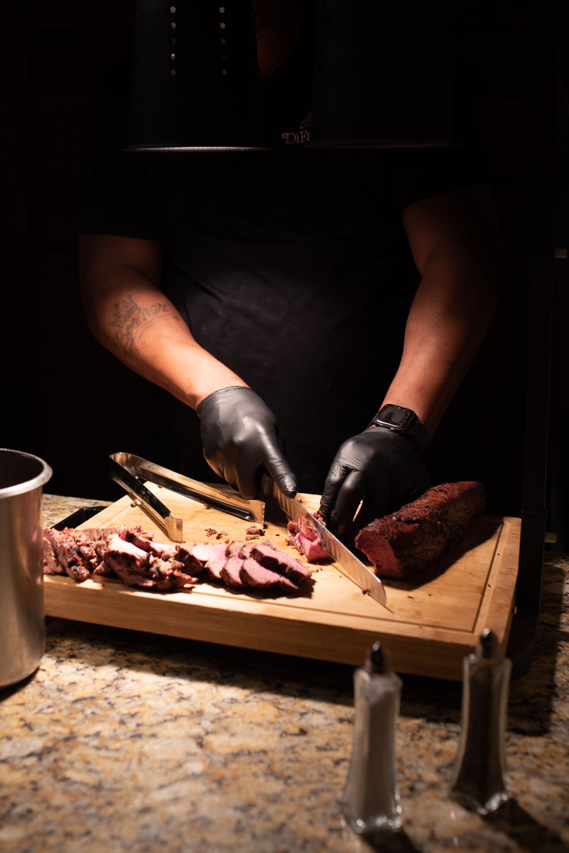 A man is cutting a piece of meat on a cutting board.