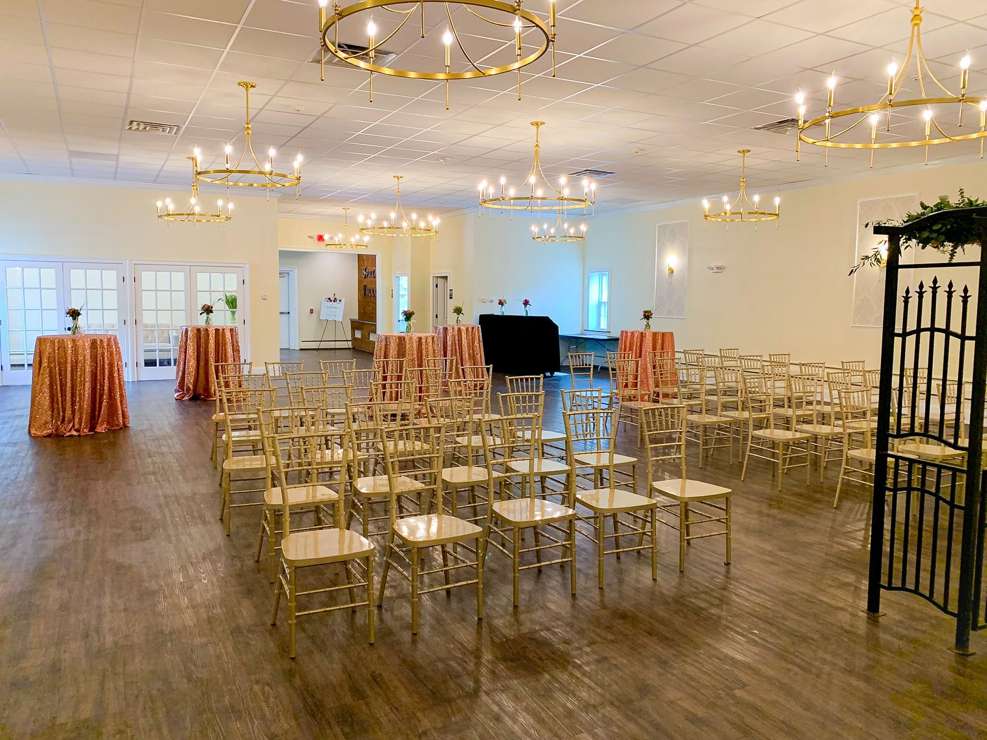 A large room with tables and chairs set up for a wedding ceremony.