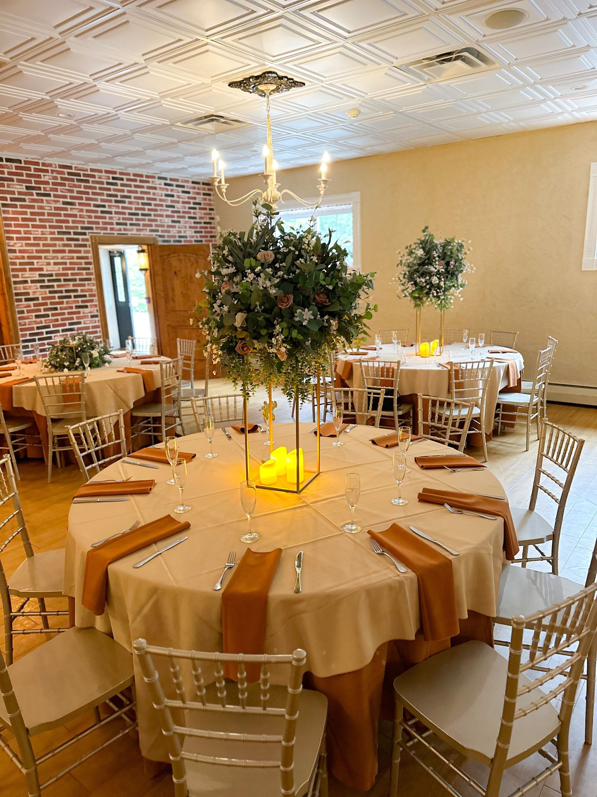A large room with tables and chairs set up for a wedding reception.