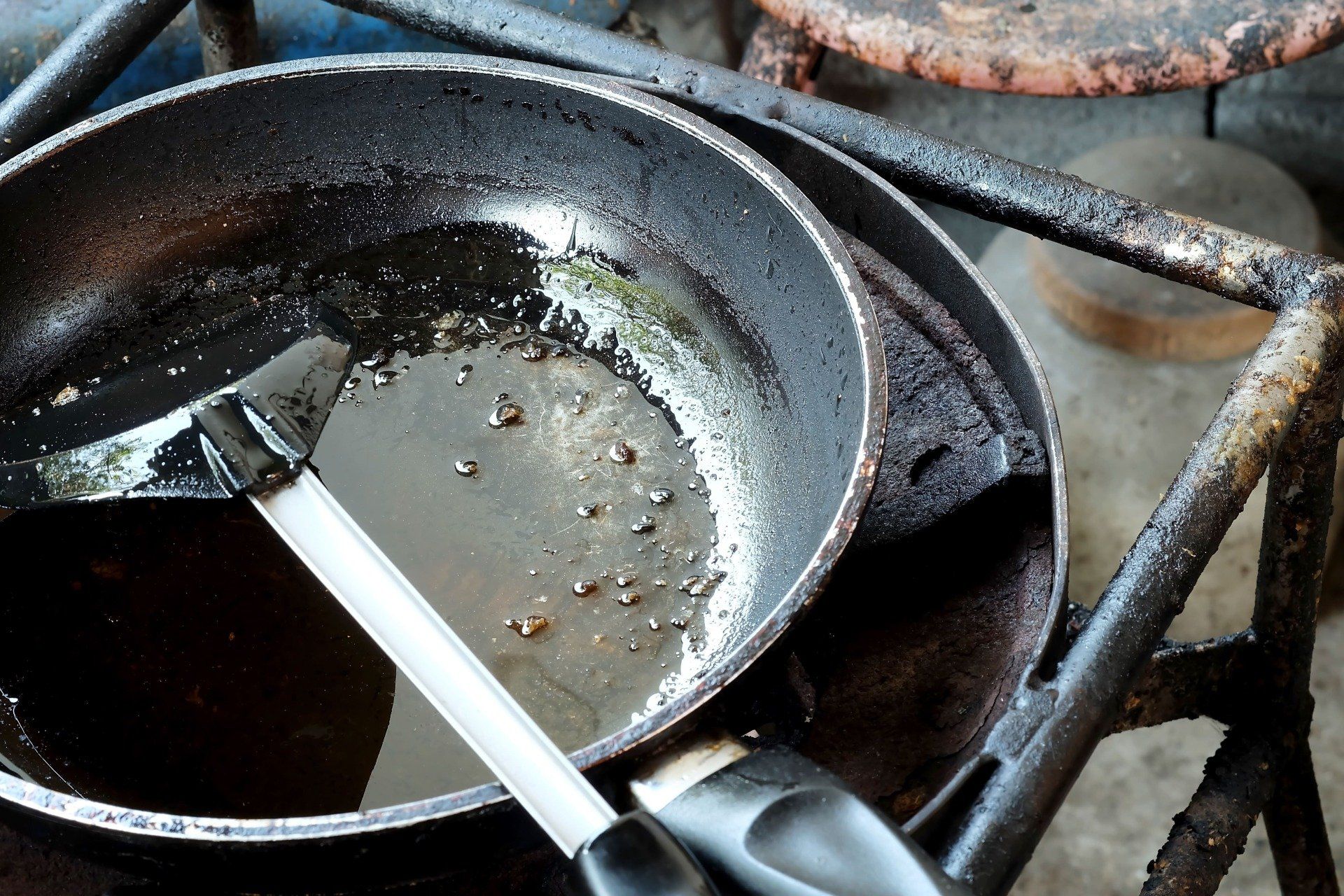 dirty pan with grease on the cook top