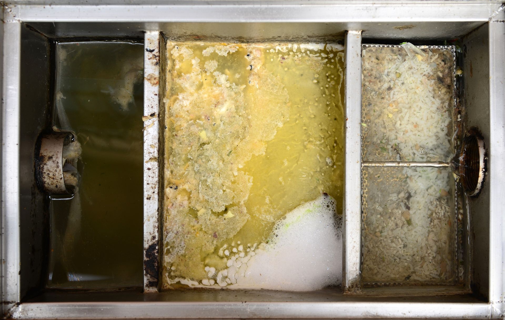 A close up of a dirty grease trap
