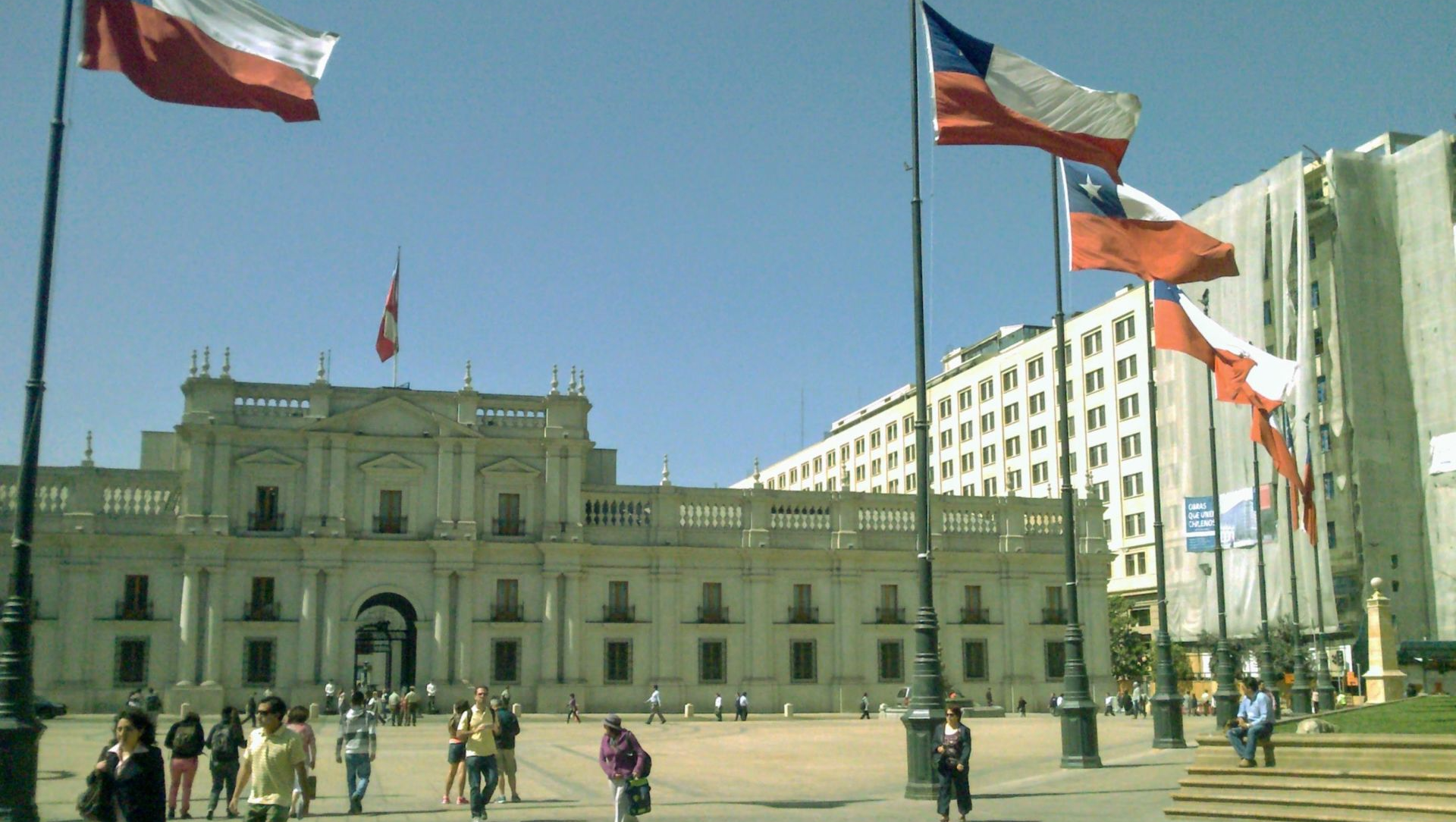 La Moneda goverment palace, flags and people walking