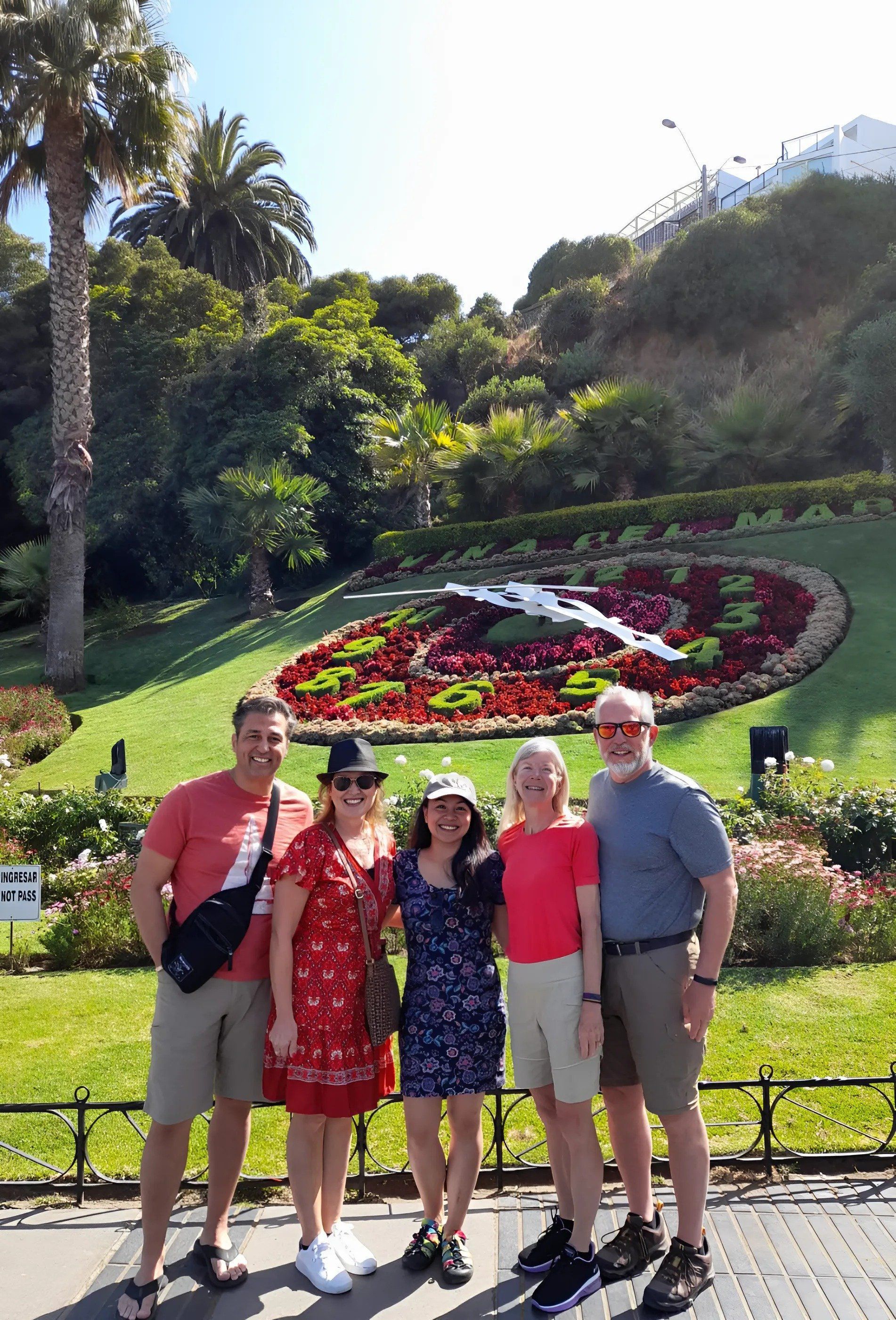 Happy tourists in front of the Viña del Mar flower clock posing for a pick