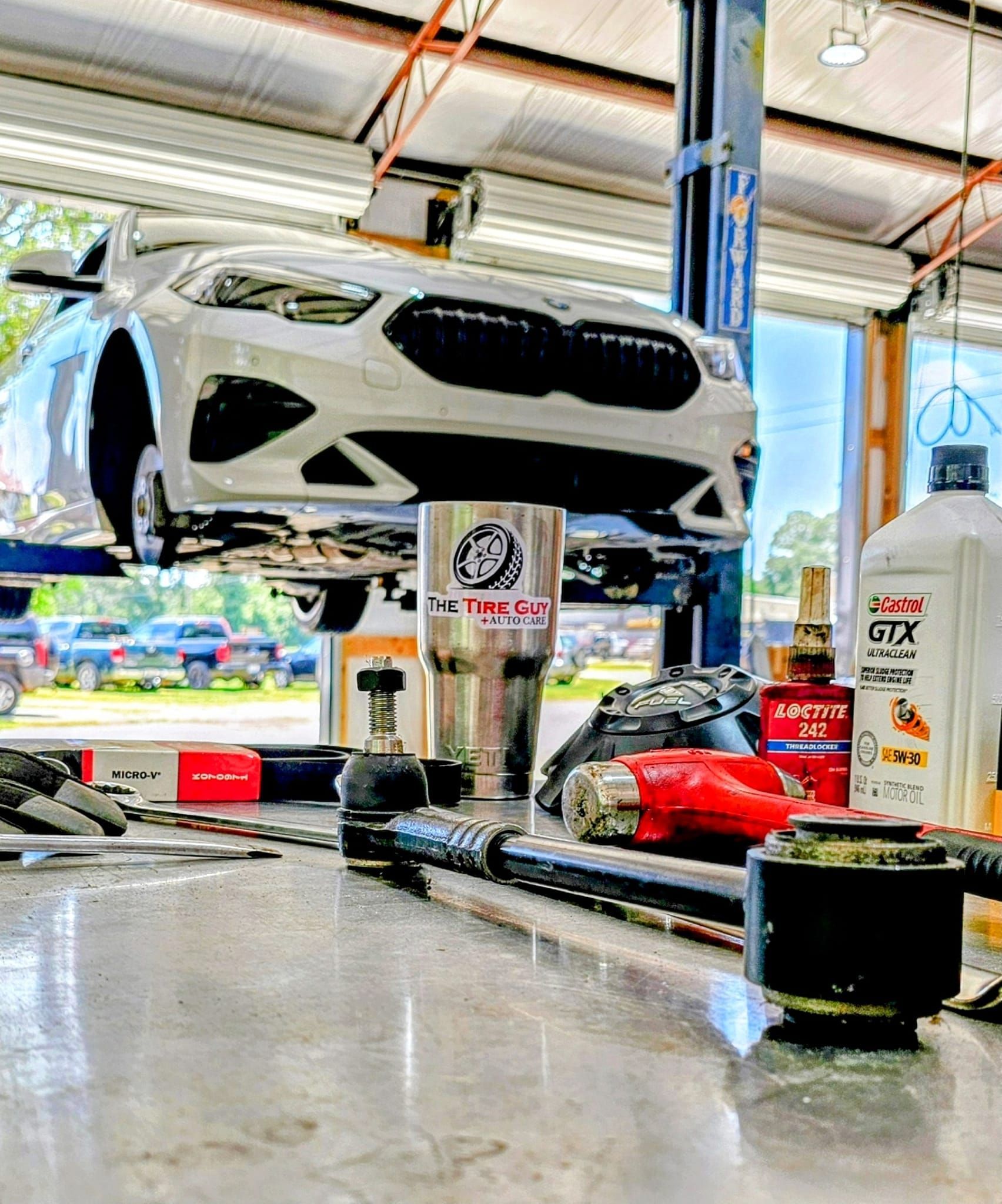 A car is sitting on a lift in a garage.