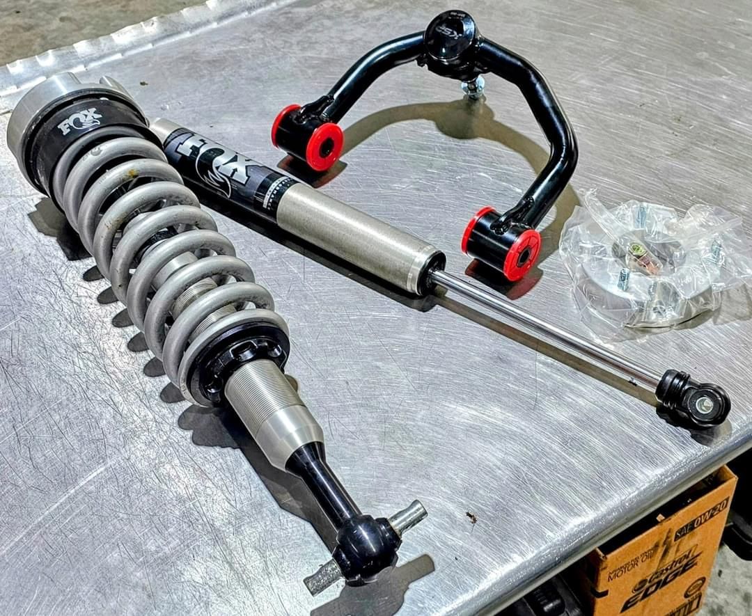 A shock absorber and a shock absorber are sitting on top of a metal table.