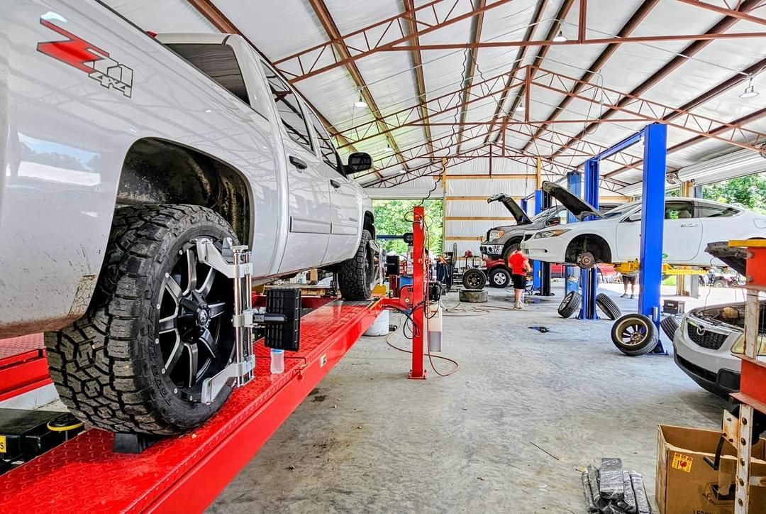 A truck is sitting on a lift in a garage.
