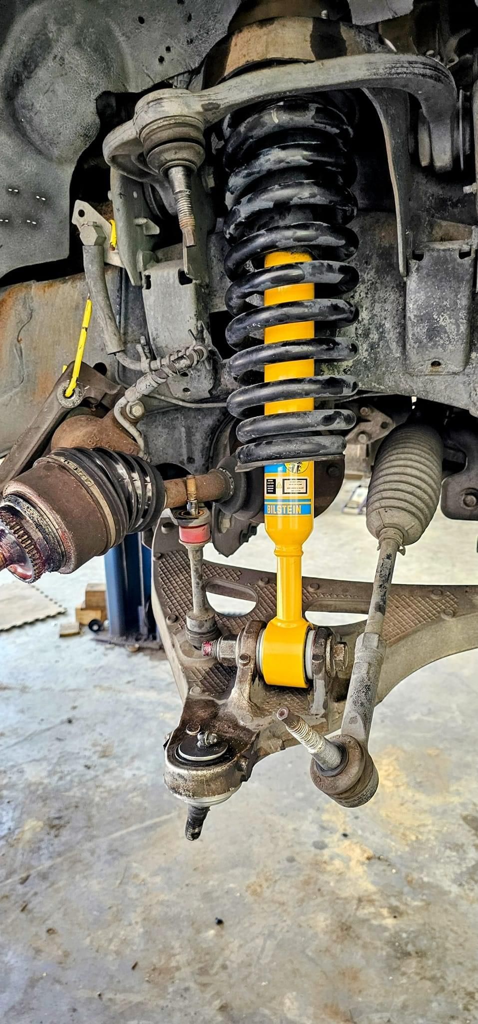 A close up of a yellow shock absorber on a car.
