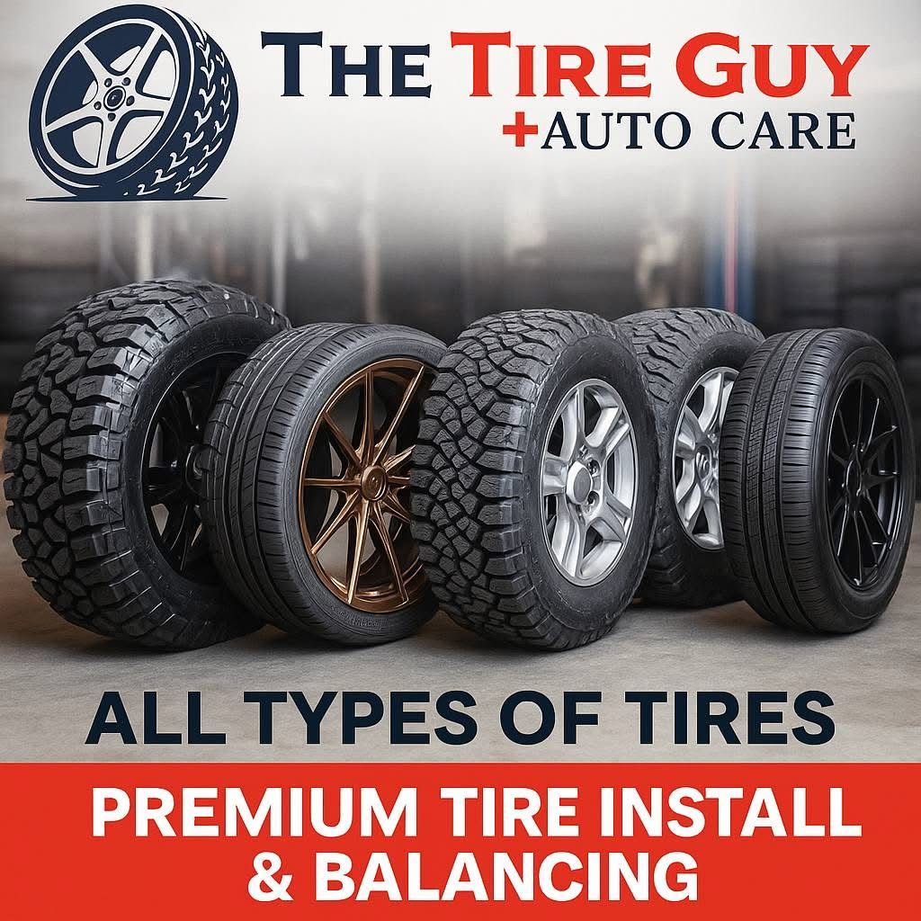 A bunch of tires are stacked in front of a garage.