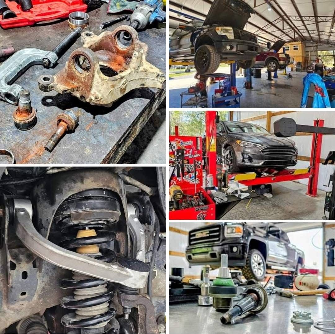 A jeep is sitting on a lift in front of a garage.
