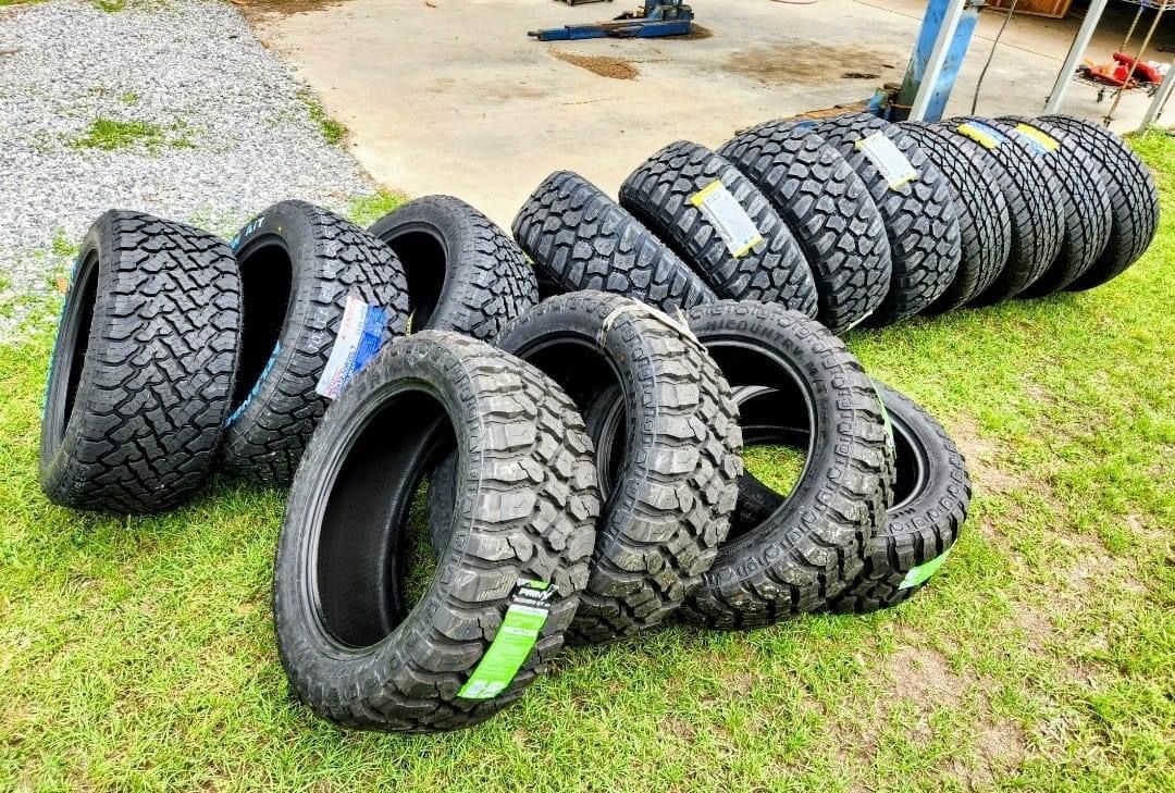A bunch of tires are stacked on top of each other on the grass.