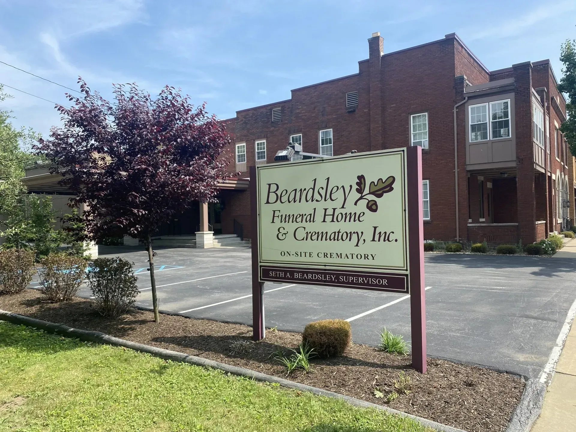 A sign in front of a brick building that says beansley 's favored home & trustory inc.