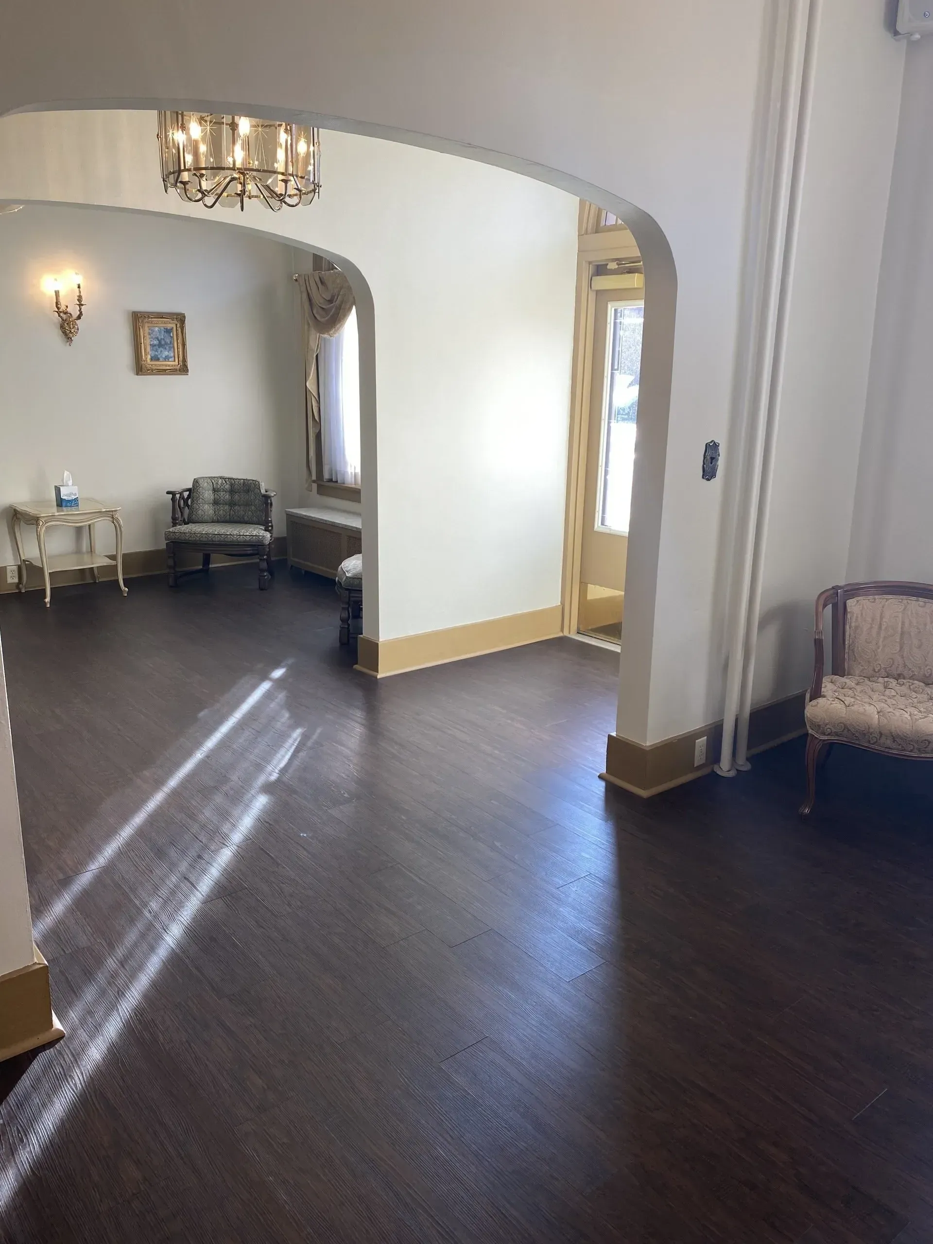 A living room with hardwood floors and white walls