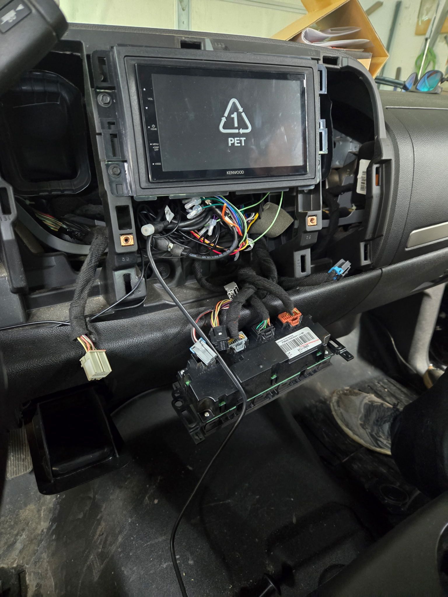 Dashboard with new car stereo installation in progress. Wires and components exposed.