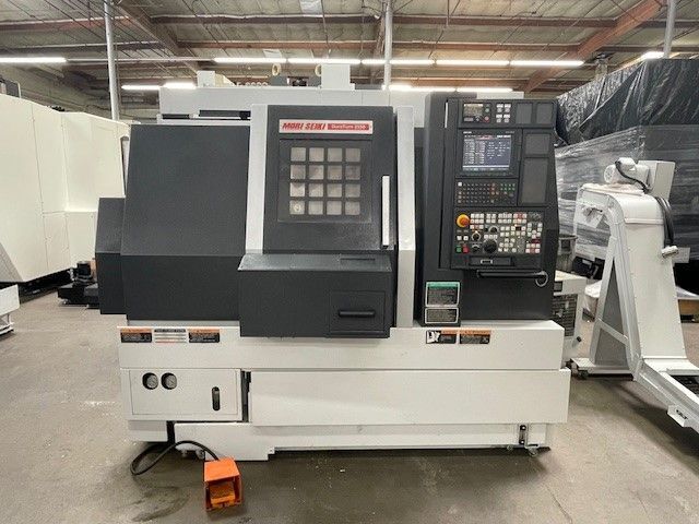 A machine is sitting on the ground in a warehouse.