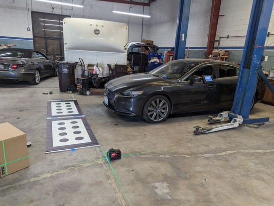 A car is sitting on a lift in a garage.