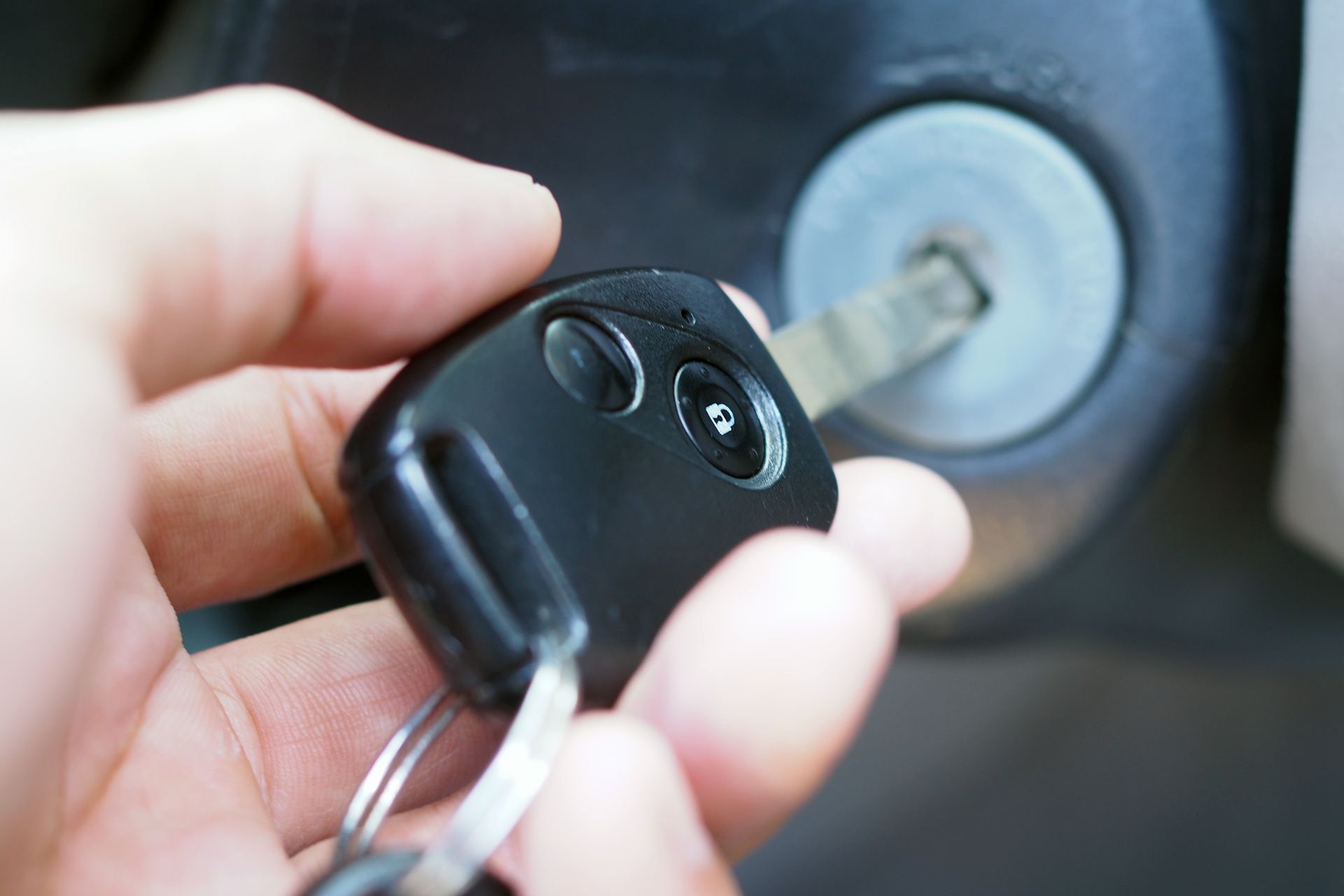 A person is holding a car key in their hand.