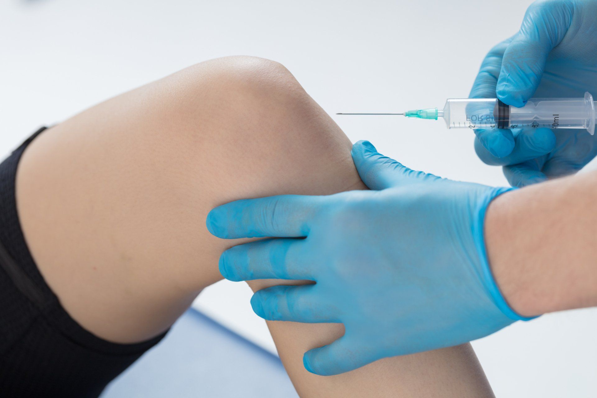 doctor injects medicine into knee