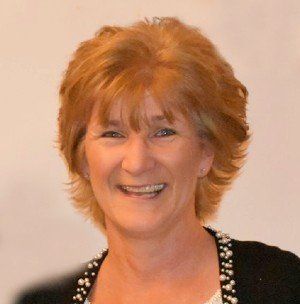 A woman with red hair is smiling for the camera