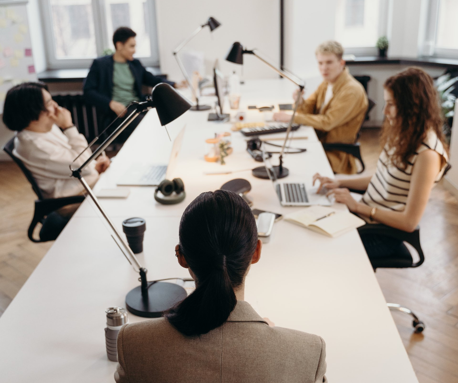 A woman with red hair is smiling for the camera while sitting in a chair.