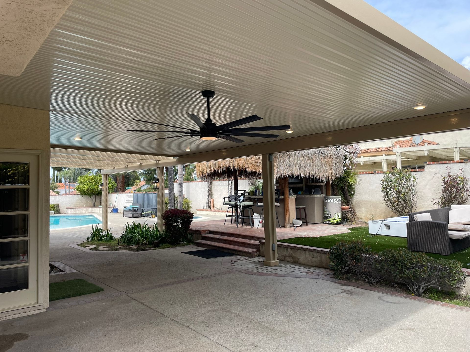 Patio with overhead structure, ceiling fan, and view of a pool and backyard.