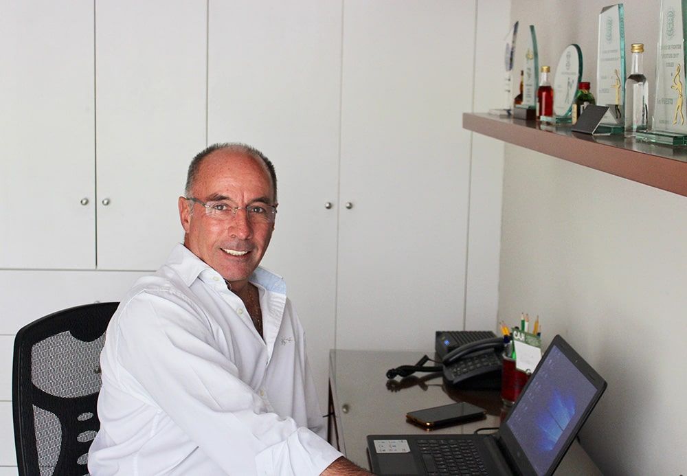 Un hombre está sentado en un escritorio frente a una computadora portátil.