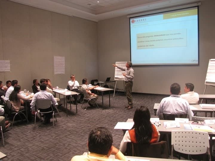 Un hombre está dando una presentación a un grupo de personas.