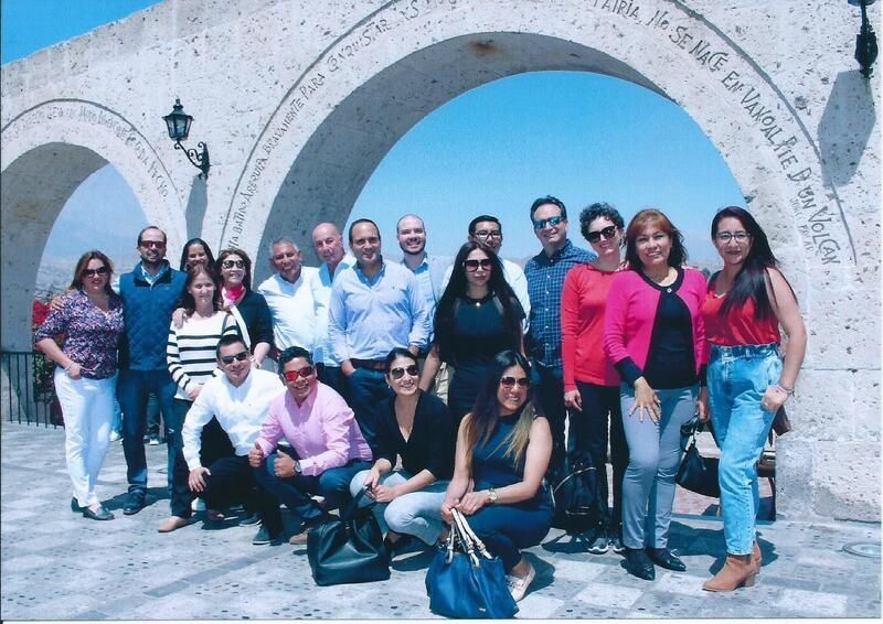 Un grupo de personas posando para una foto frente a un arco de piedra.