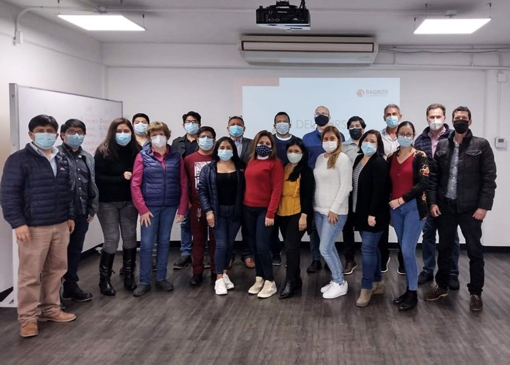 Un grupo de personas con mascarillas posan para una fotografía en una habitación.