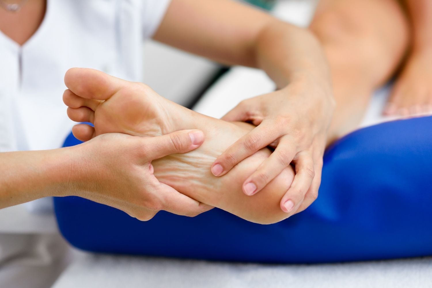 A woman is giving a foot massage to another woman.