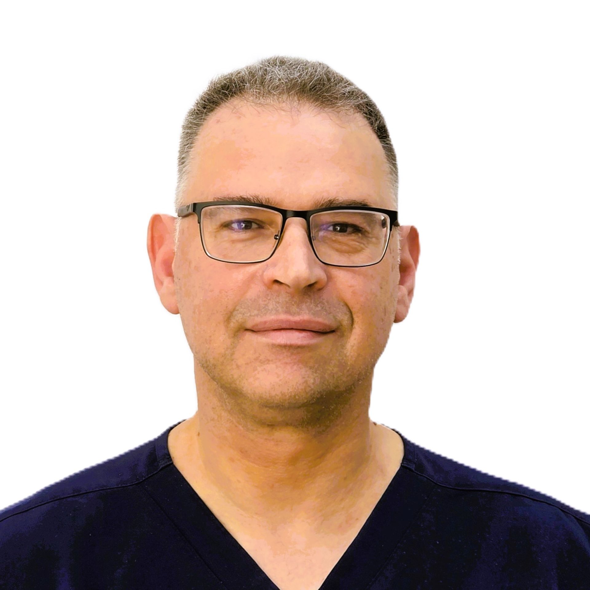 A man wearing glasses and a polka dot shirt is smiling for the camera.