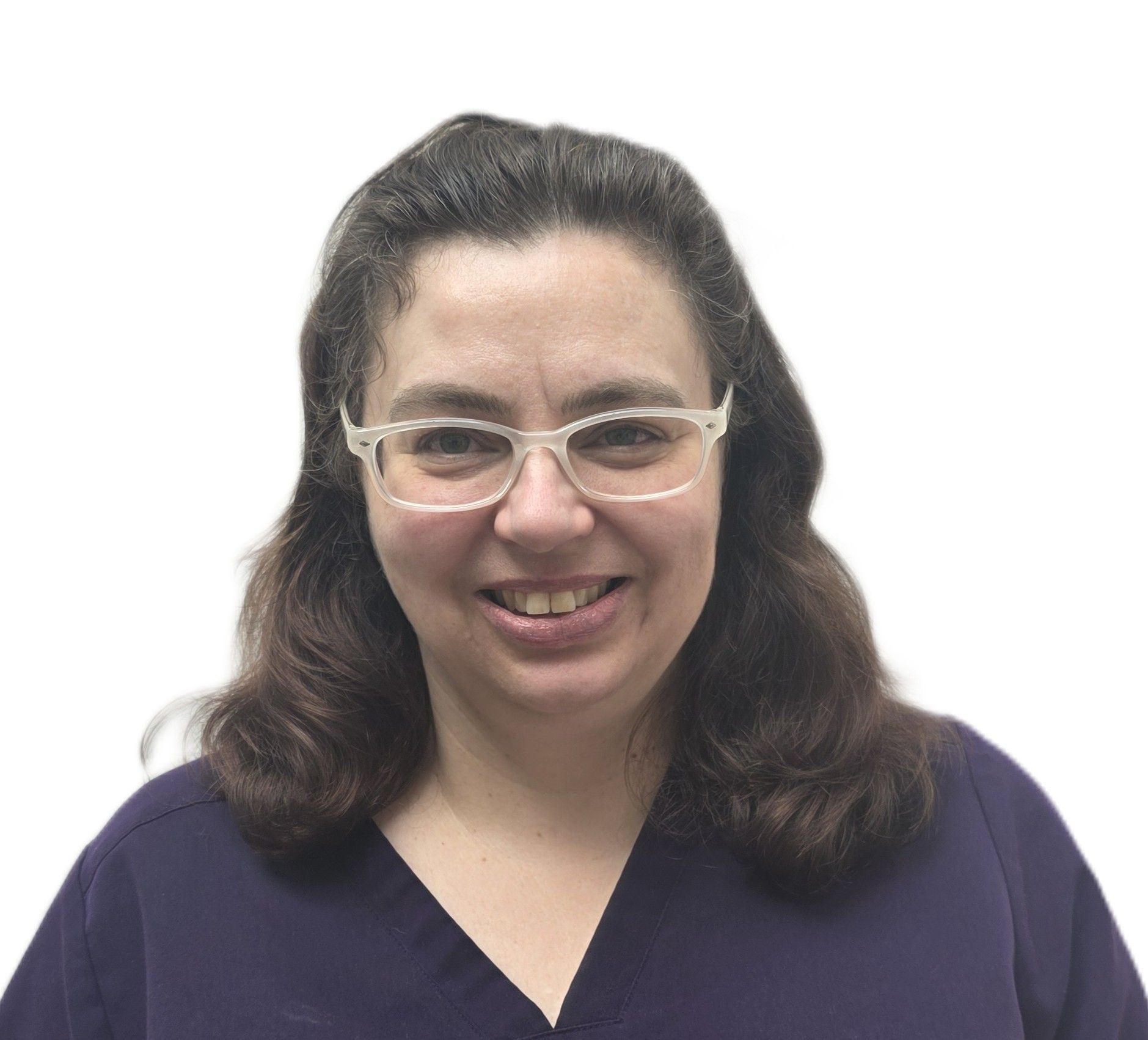 A woman wearing glasses and a scrub top is smiling for the camera.