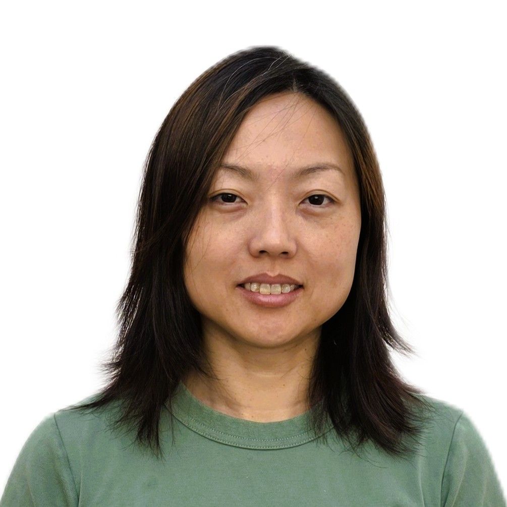 A woman with short hair is wearing a white shirt and smiling.