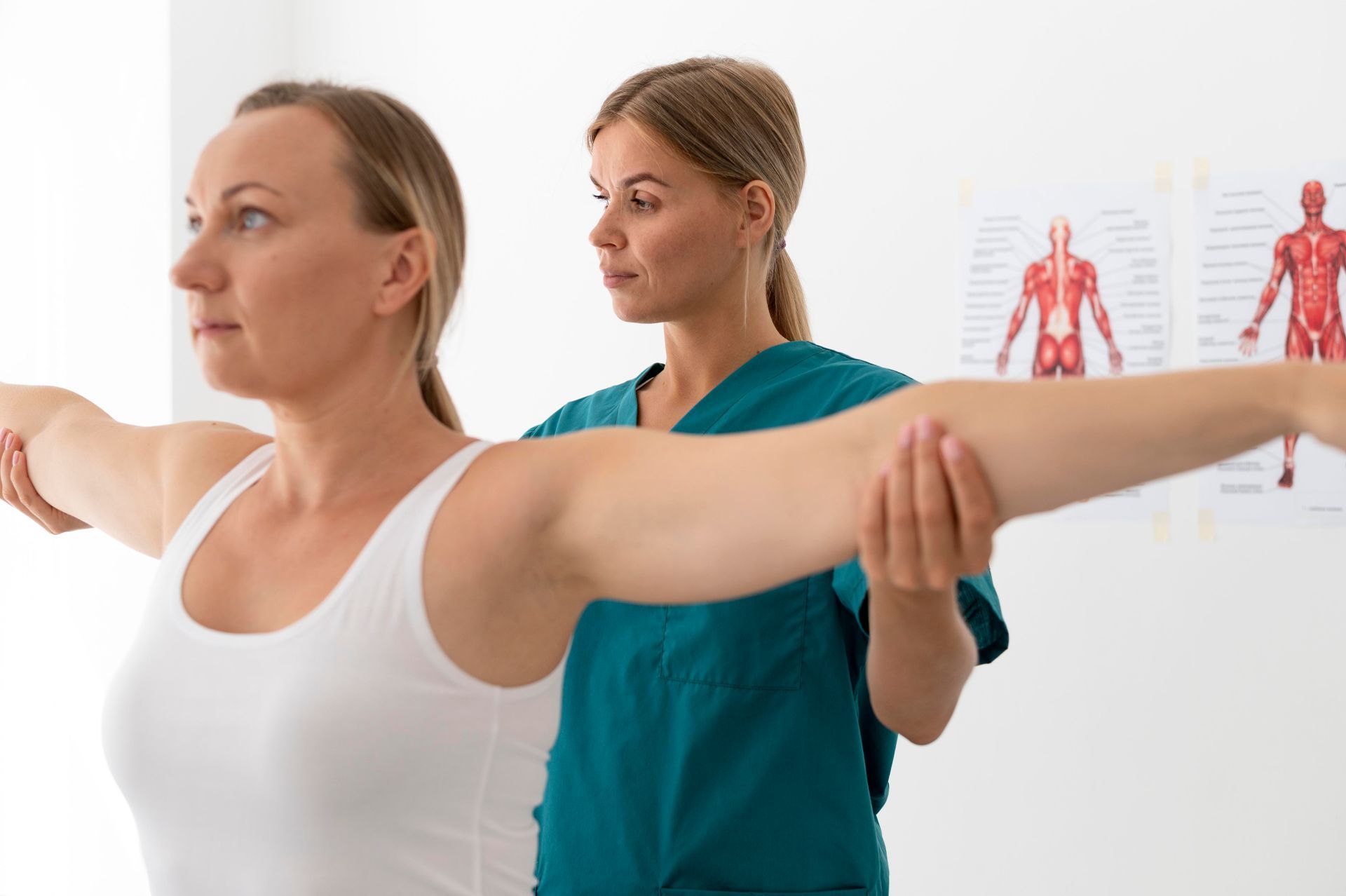 A woman is being examined by a nurse while stretching her arms.