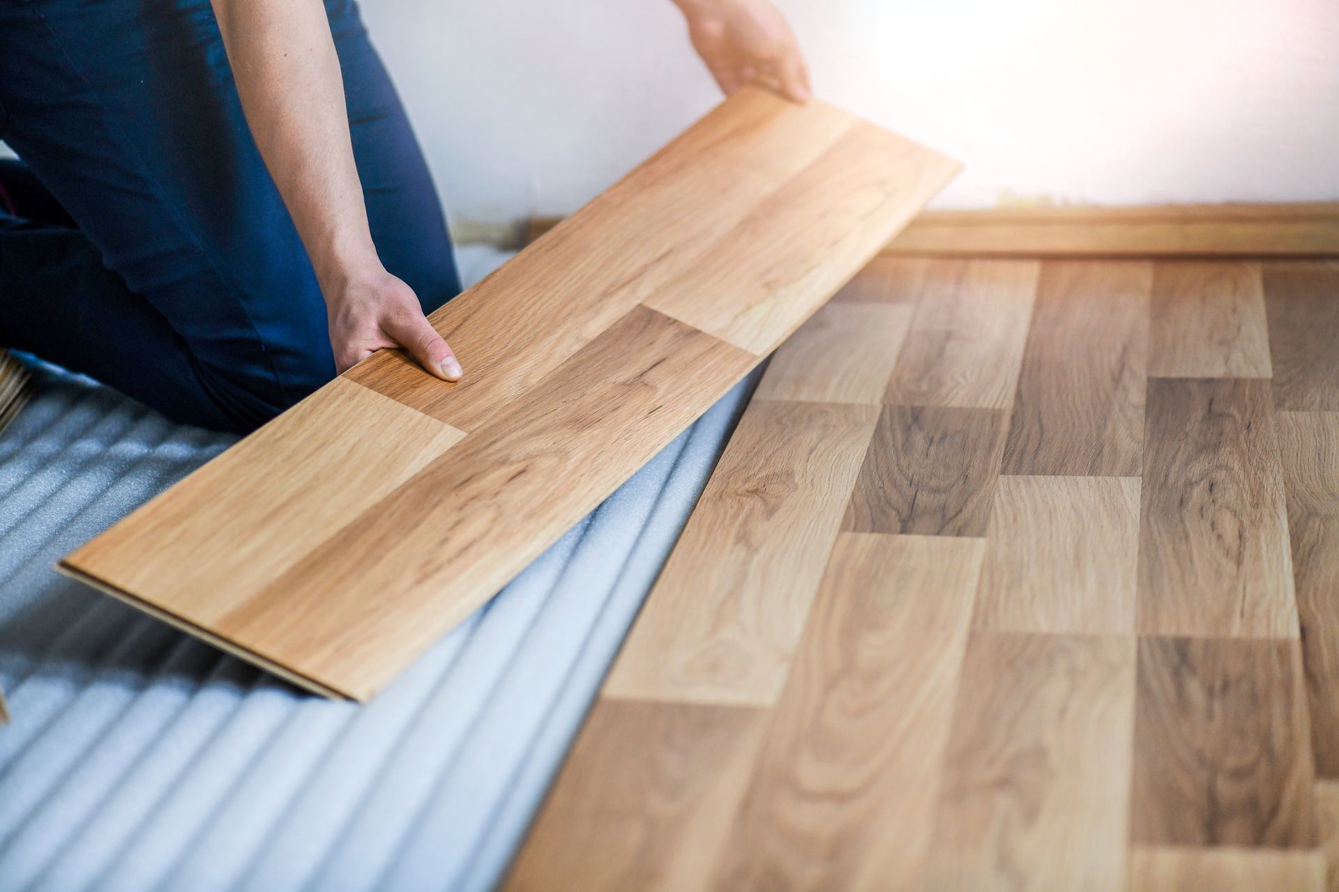 a person is installing a wooden floor in a room 