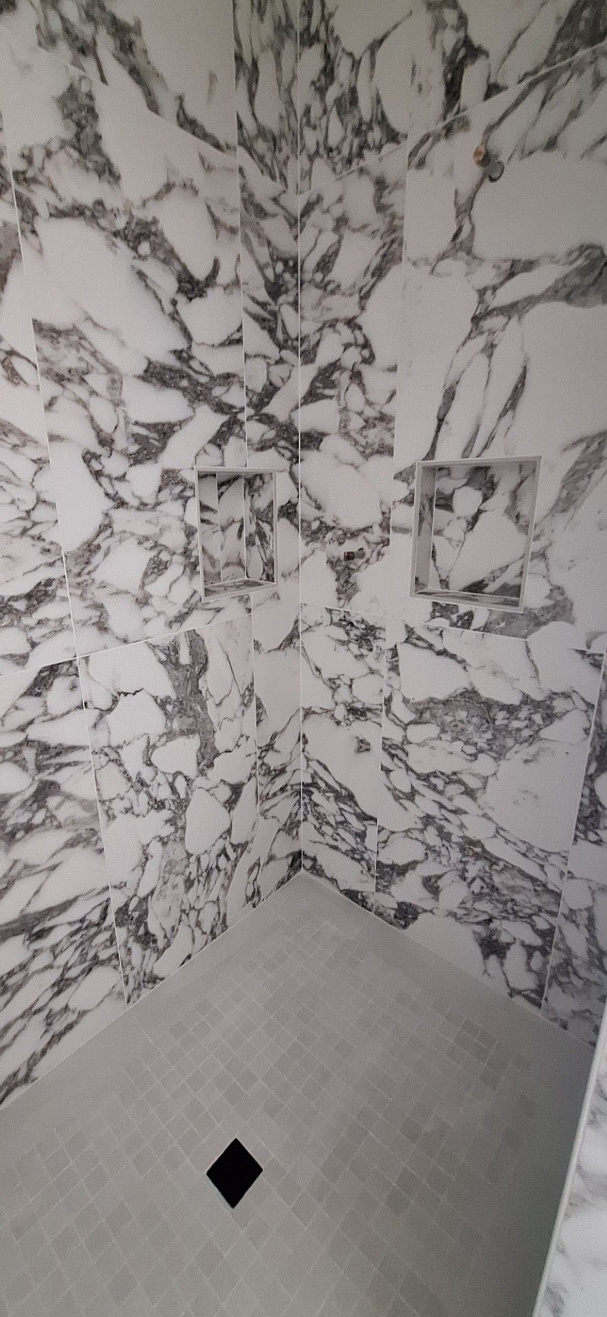 Gravel driveway leading to a modern house with wooden facade, under a carport.