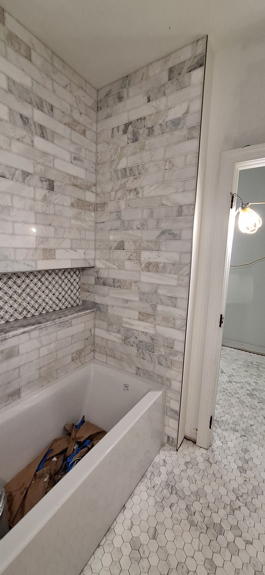 Modern bathroom with wood vanity, glass shower, large mirror, and neutral tones.